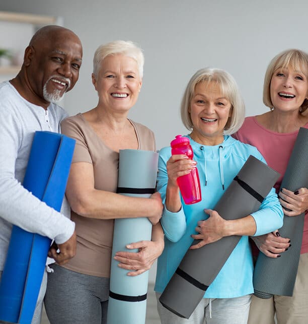 Man and women holding yoga mat and pink water bottle