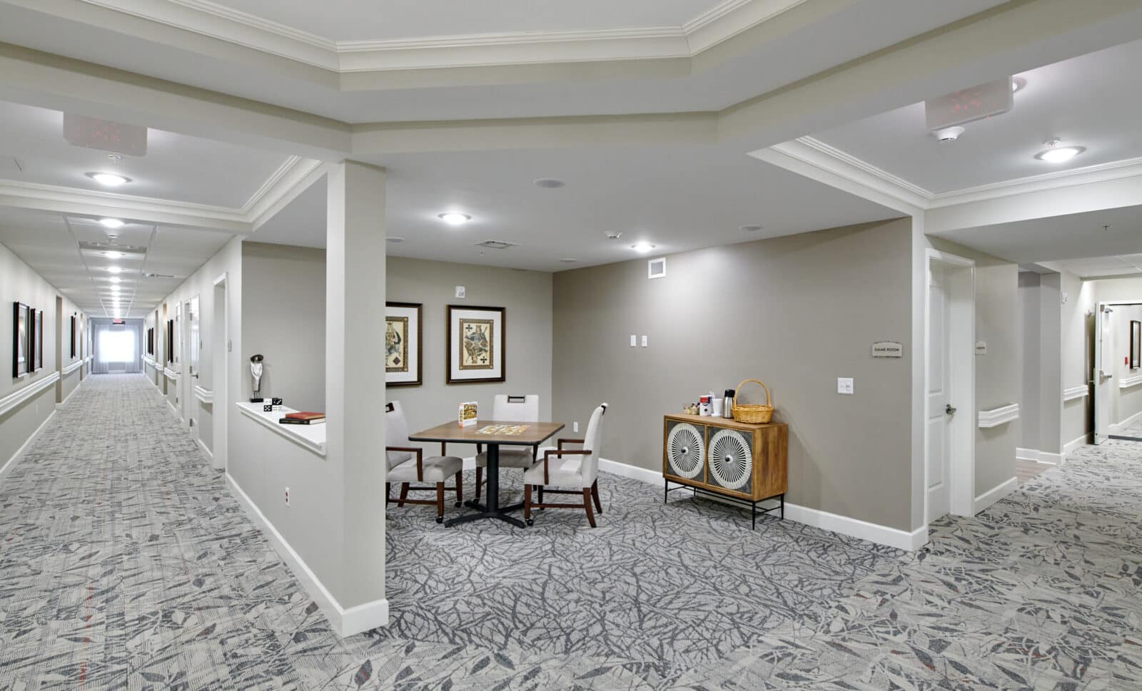 white hallway with game table with three chairs and piece of furniture
